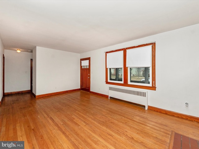 empty room with radiator heating unit and light wood-type flooring