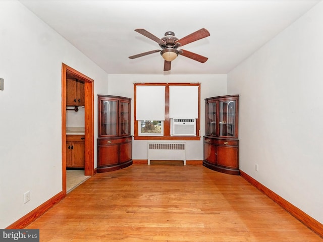 interior space featuring cooling unit, ceiling fan, radiator heating unit, and light hardwood / wood-style flooring