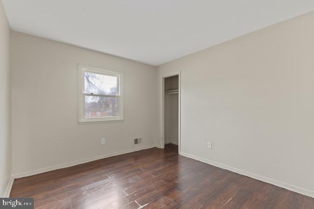 unfurnished bedroom featuring a closet and dark hardwood / wood-style floors