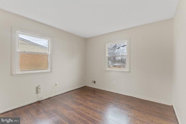 unfurnished room with dark hardwood / wood-style floors