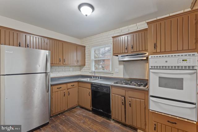 kitchen featuring tasteful backsplash, appliances with stainless steel finishes, sink, and dark hardwood / wood-style floors