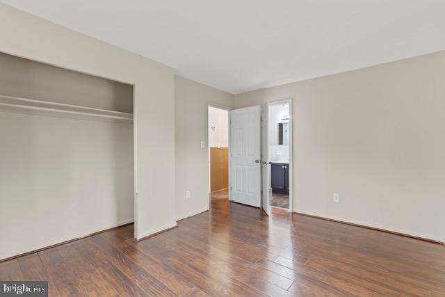 unfurnished bedroom featuring dark hardwood / wood-style flooring and a closet