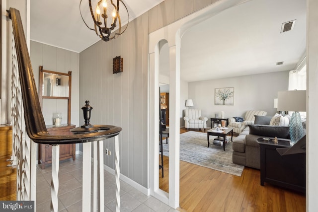 hall featuring hardwood / wood-style floors and an inviting chandelier