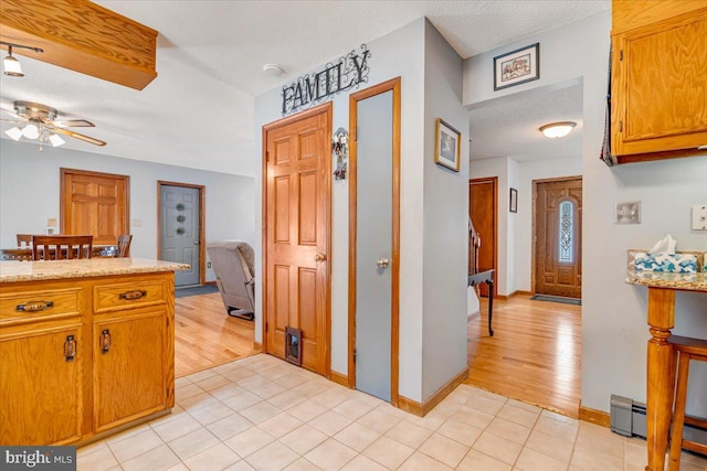 kitchen featuring light tile patterned floors, a textured ceiling, and ceiling fan