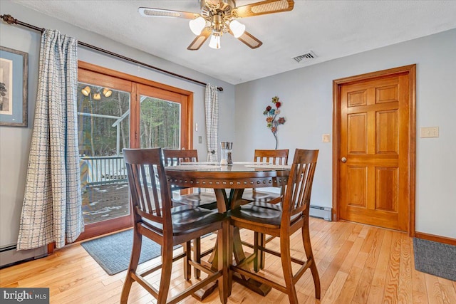 dining area with a baseboard radiator, ceiling fan, a textured ceiling, and light wood-type flooring