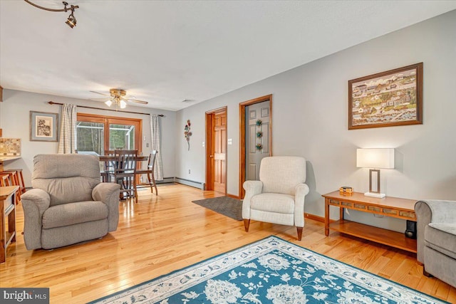 living room featuring hardwood / wood-style flooring, a baseboard radiator, and ceiling fan