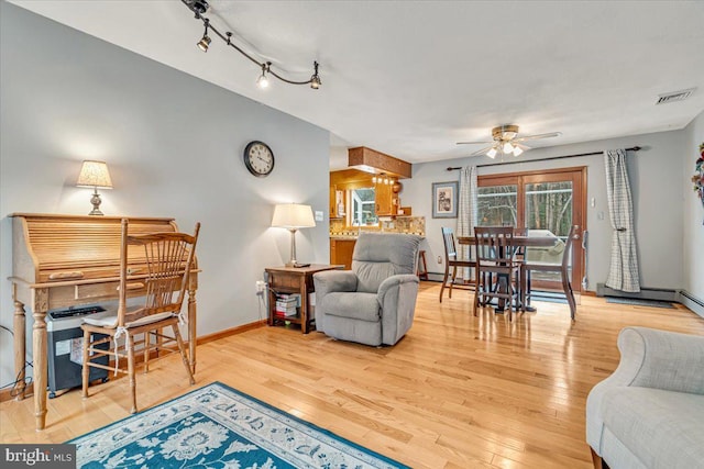 living room featuring hardwood / wood-style flooring, rail lighting, and ceiling fan