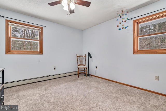 spare room with a baseboard heating unit, ceiling fan, a textured ceiling, and carpet flooring