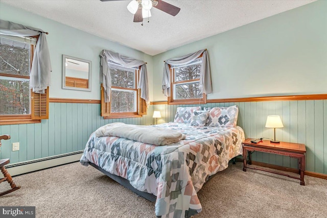 carpeted bedroom featuring ceiling fan, a textured ceiling, and baseboard heating