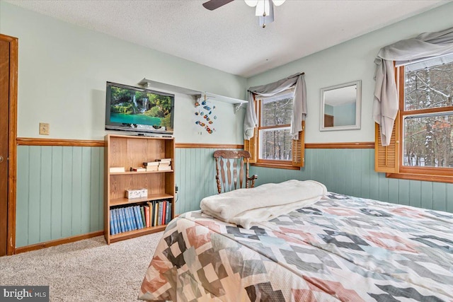 bedroom with ceiling fan, a textured ceiling, and carpet