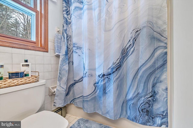 bathroom with tile walls, tile patterned floors, and toilet