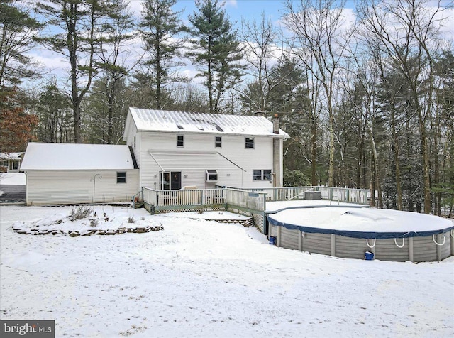 snow covered house featuring a swimming pool side deck