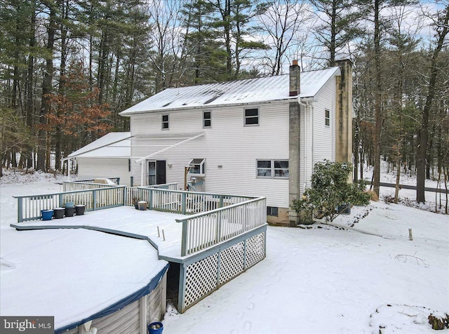 snow covered house featuring a deck