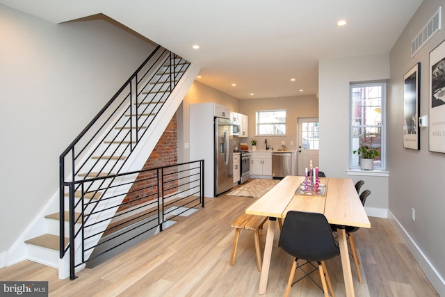 dining room with sink and light wood-type flooring