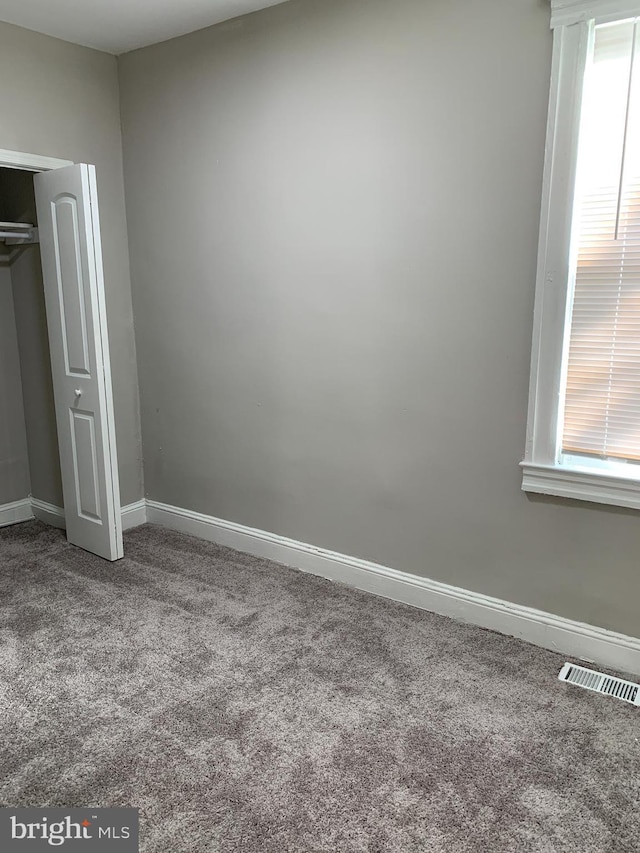 unfurnished bedroom featuring carpet floors and a closet