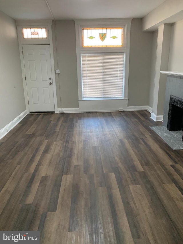 foyer with dark hardwood / wood-style flooring and a tiled fireplace