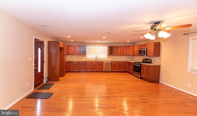 kitchen featuring sink, light hardwood / wood-style floors, ceiling fan, and appliances with stainless steel finishes