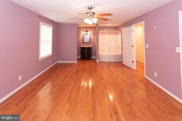 unfurnished living room featuring ceiling fan and light hardwood / wood-style flooring