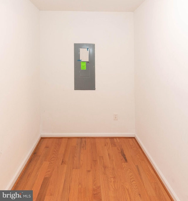 empty room with electric panel and light wood-type flooring