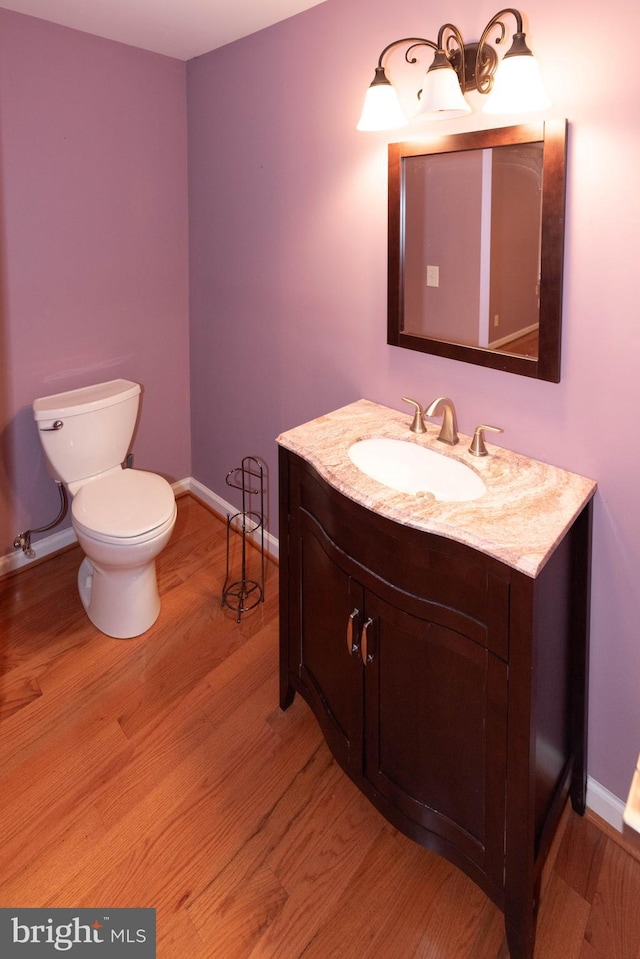 bathroom with vanity, hardwood / wood-style floors, and toilet