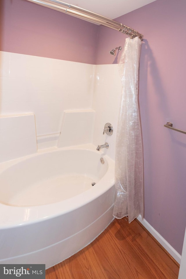 bathroom featuring hardwood / wood-style flooring and shower / tub combo