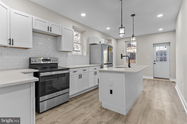 kitchen with sink, white cabinetry, stainless steel appliances, light stone countertops, and light wood-type flooring