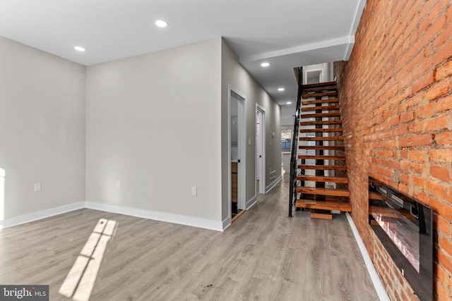 interior space featuring brick wall and wood-type flooring