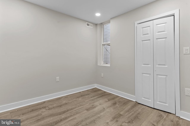 unfurnished bedroom featuring light wood-type flooring and a closet