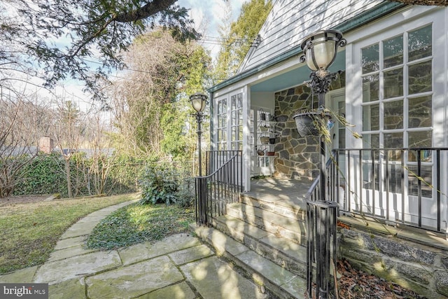 view of home's exterior with stone siding and fence