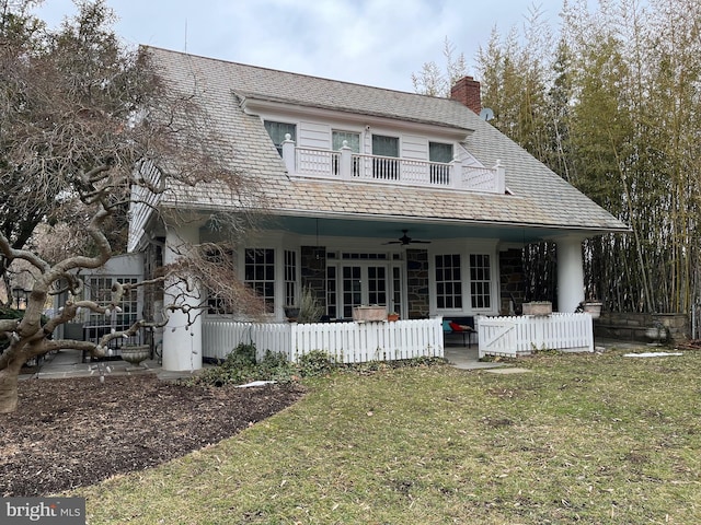 view of front of property with a front yard, fence, and a ceiling fan