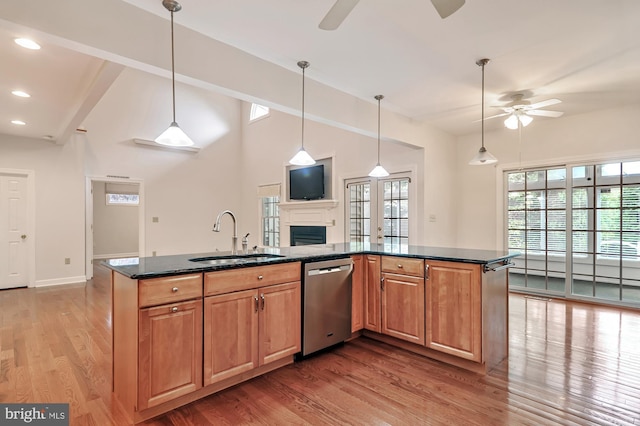 kitchen featuring sink, hardwood / wood-style flooring, dishwasher, ceiling fan, and dark stone countertops