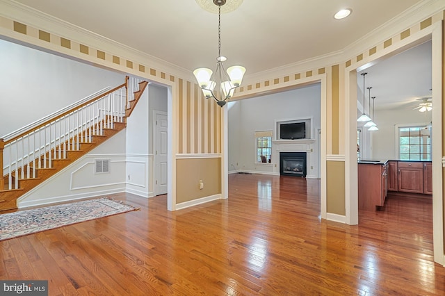 interior space featuring hardwood / wood-style flooring, crown molding, and a healthy amount of sunlight