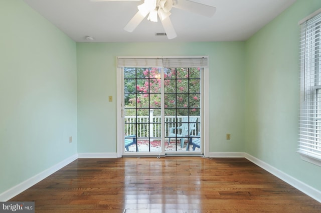 empty room with dark wood-type flooring and ceiling fan