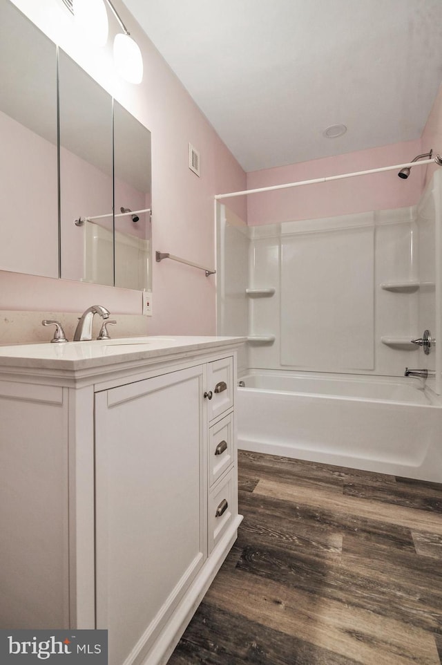 bathroom with vanity, hardwood / wood-style flooring, and shower / bathtub combination