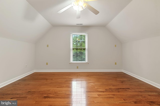 additional living space with hardwood / wood-style flooring, lofted ceiling, and ceiling fan