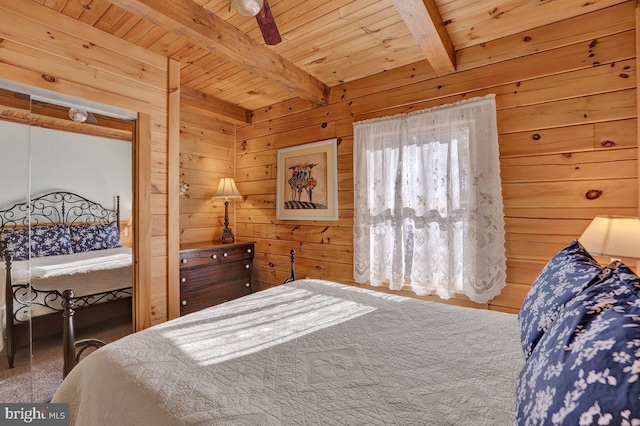 bedroom with beamed ceiling, wooden walls, and wooden ceiling