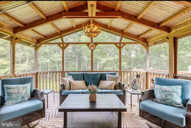 sunroom featuring lofted ceiling and a notable chandelier