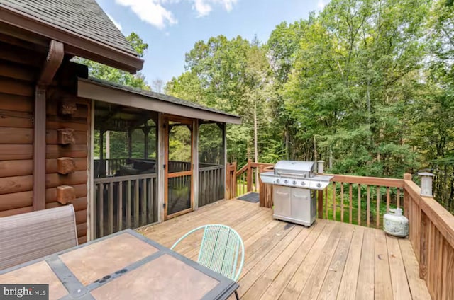 wooden deck with a grill and a sunroom