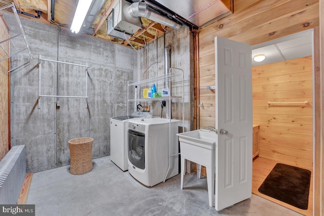 washroom featuring separate washer and dryer and wood walls