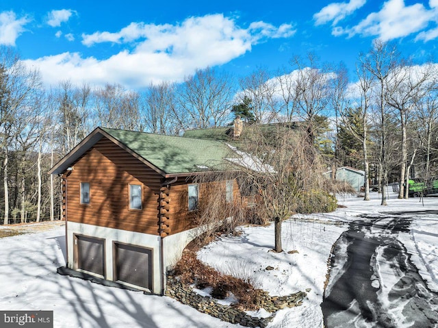 snow covered property with a garage