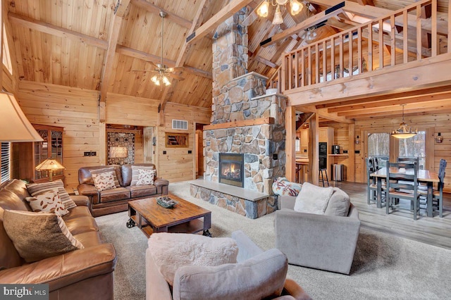 living room with wood ceiling, ceiling fan, a fireplace, and wood walls