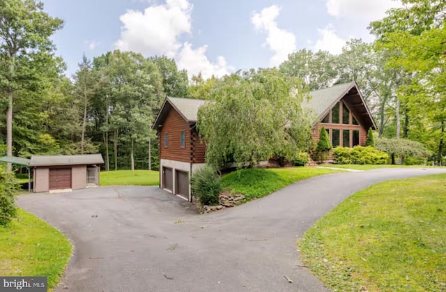 view of front of house featuring a garage, an outdoor structure, and a front yard