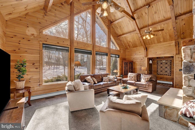 carpeted living room featuring plenty of natural light, wooden ceiling, baseboard heating, and wood walls