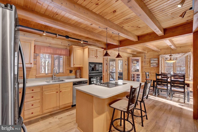 kitchen with sink, a center island, hanging light fixtures, light brown cabinets, and black appliances