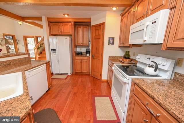 kitchen featuring light stone counters, sink, white appliances, and light hardwood / wood-style floors