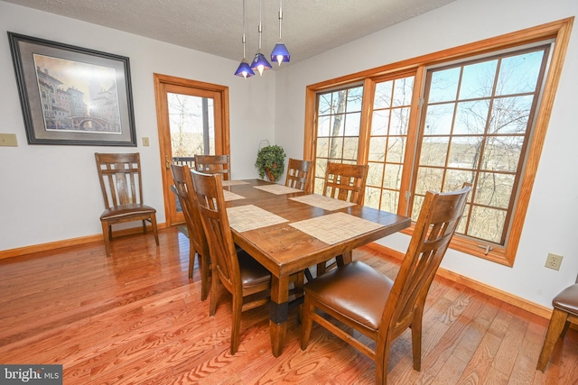 dining area featuring a textured ceiling and light hardwood / wood-style floors