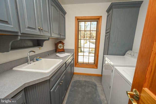 clothes washing area with cabinets, sink, and washing machine and clothes dryer