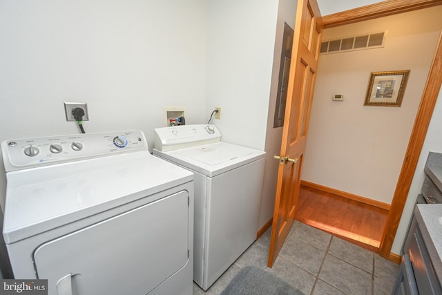 washroom with washing machine and clothes dryer and light tile patterned floors