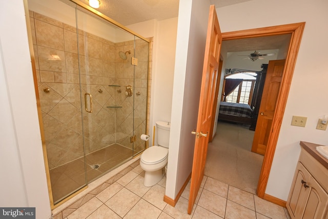 bathroom featuring tile patterned flooring, vanity, an enclosed shower, and toilet