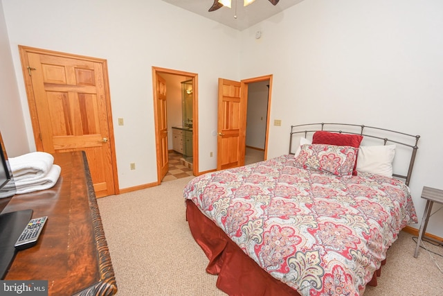 carpeted bedroom with ceiling fan, connected bathroom, and high vaulted ceiling